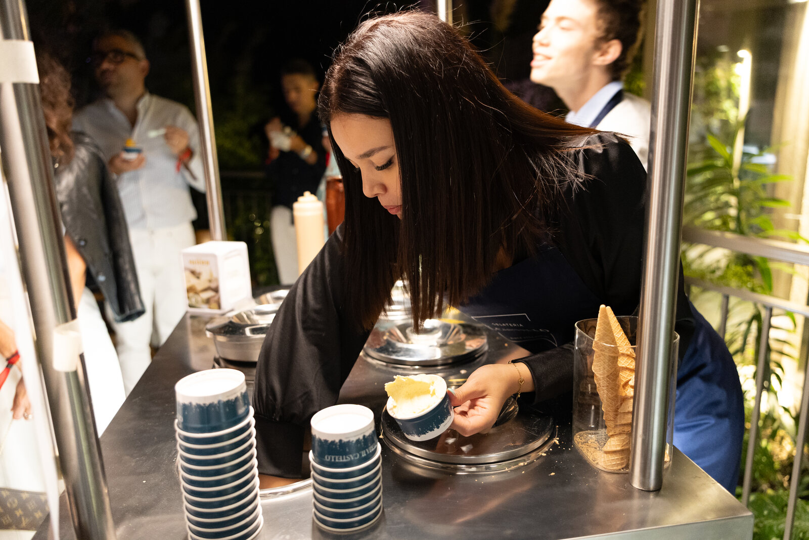 Preparazione di una coppetta di gelato al carrettino durante un evento